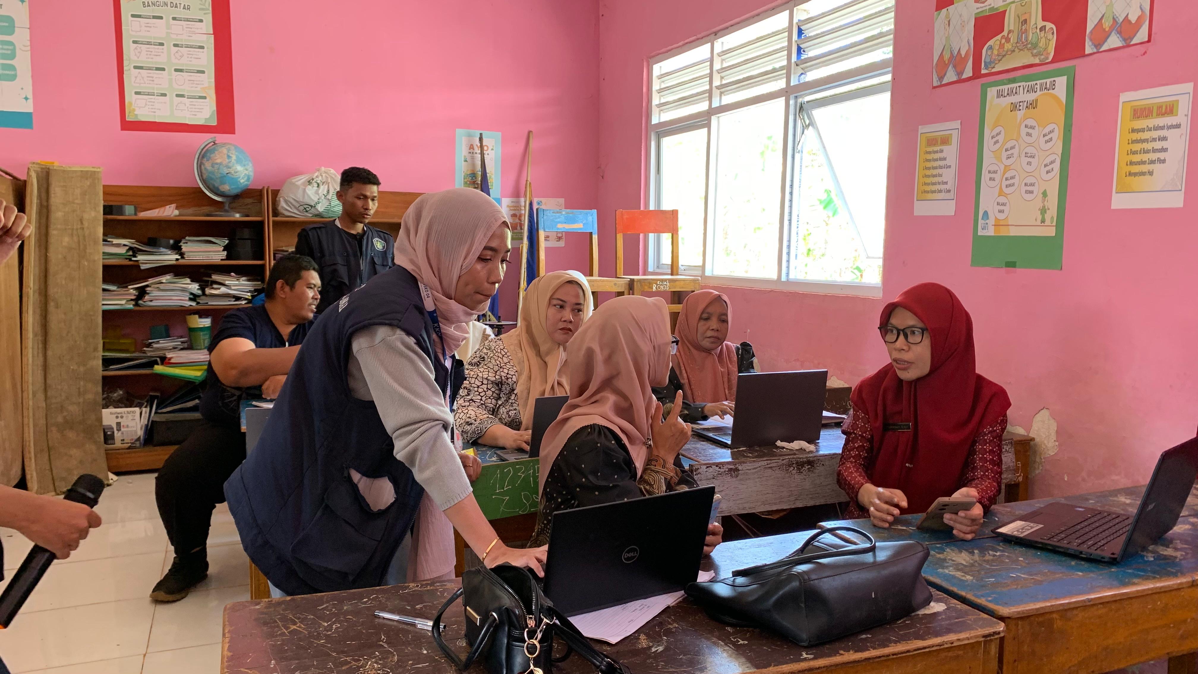 Mahasiswi KKN mendampingi guru mempraktikkan tools AI di laptop